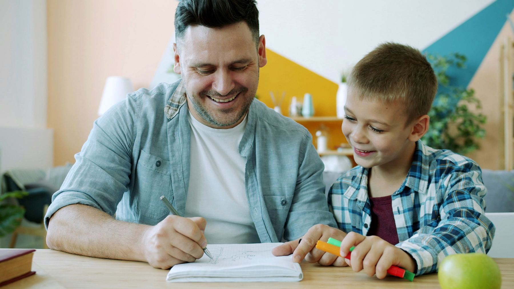 Parent and child working together on a learning activity at home