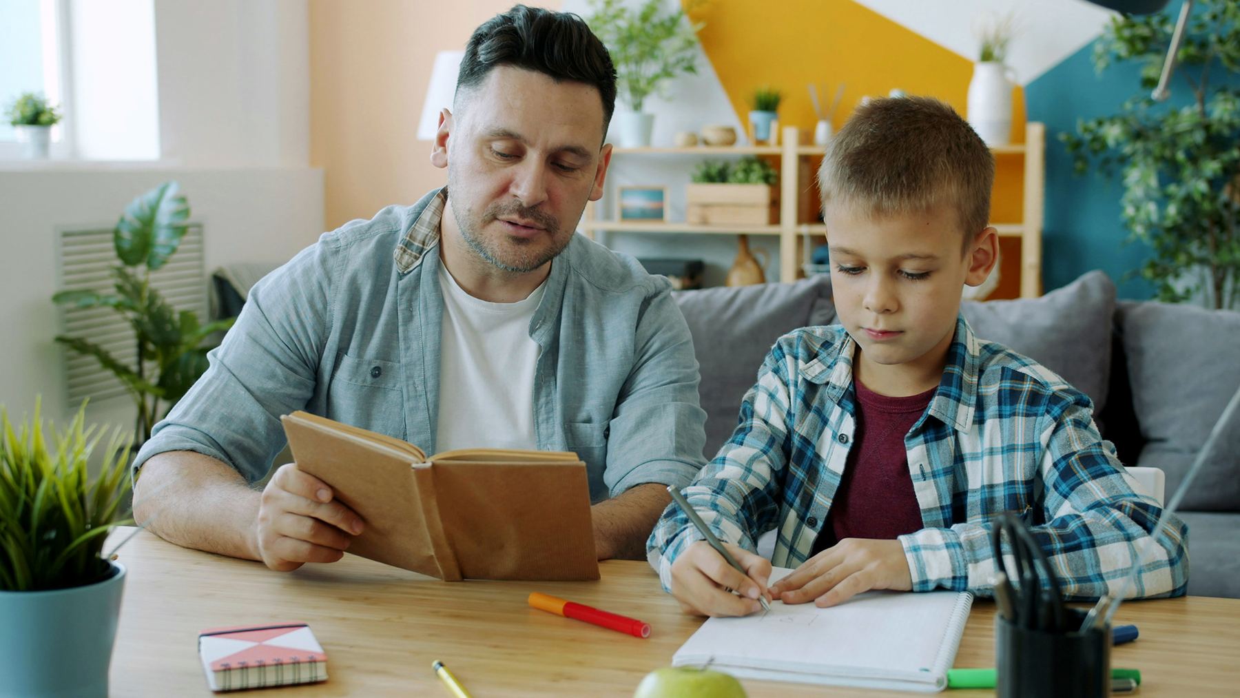 Parent and child working together on a learning activity at home